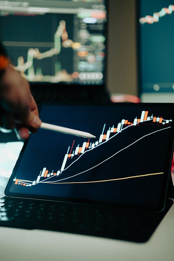 who-we-are Close-up of a digital tablet showing a financial growth chart with graphs and trends under analysis.